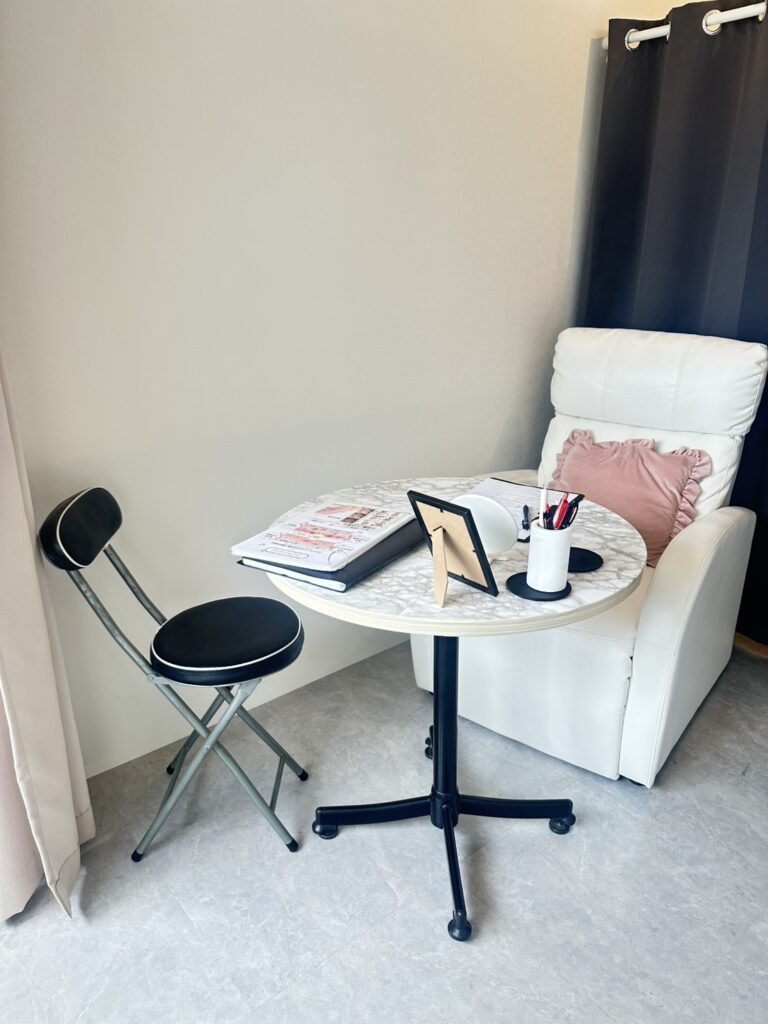 大理石調の丸テーブルと白いソファが置かれたClassy&TrueMeの落ち着いたカウンセリングスペース