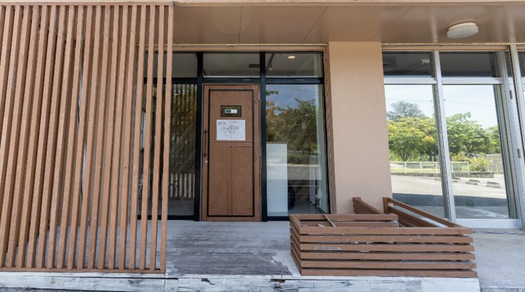 沖縄県名護市の脱毛・フェイシャルエステサロンClassy&TrueMeの落ち着いた木目調の店舗外観と入り口